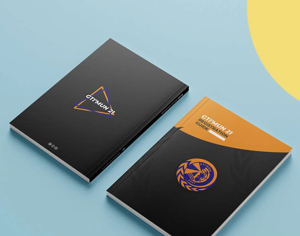 Two copies of the GTI’MUN 21 registration guide in black, one showing the conference mark and the other the title on an orange band above the emblem.